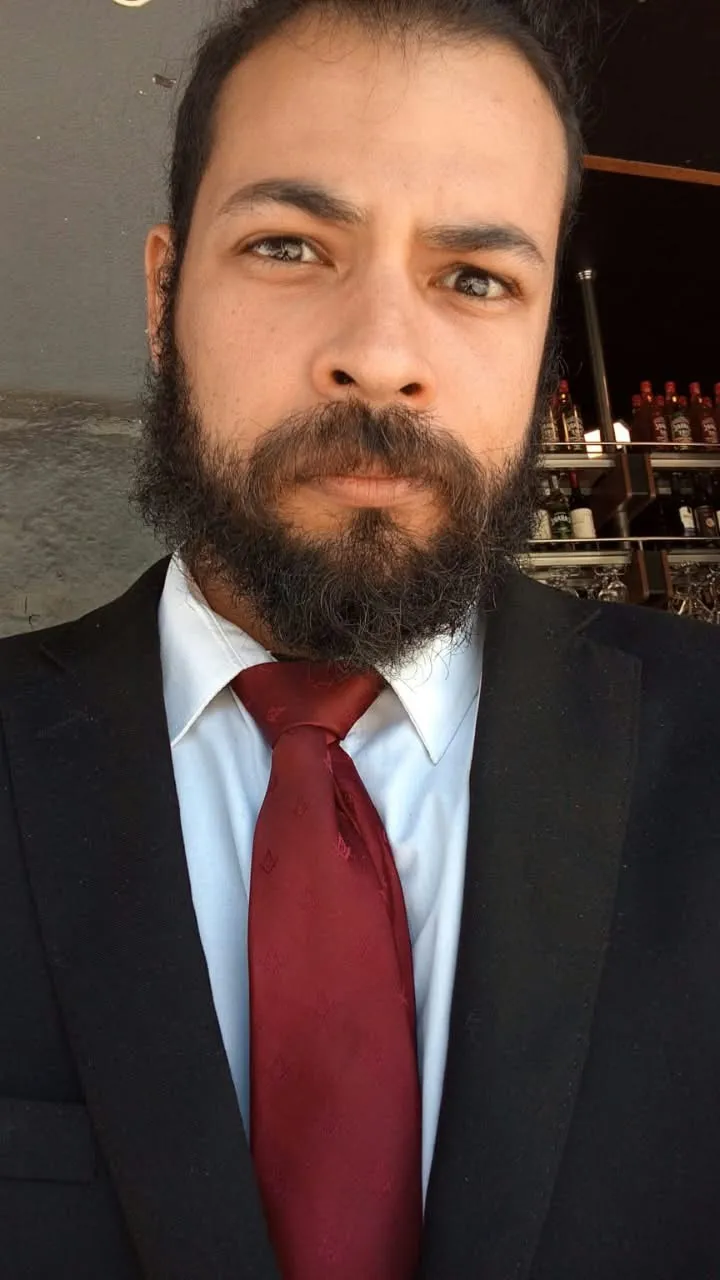 Lucas Cavalcante, de terno e gravata, olhando para a câmera
